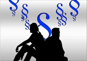 Weiblicher und männlicher Schatten sitzen unter Paragraphen zur Illustrierung der rechtlichen Betreuung